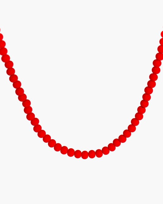 Red beaded necklace on a white background