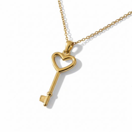 Gold key-shaped pendant on a chain against a white background