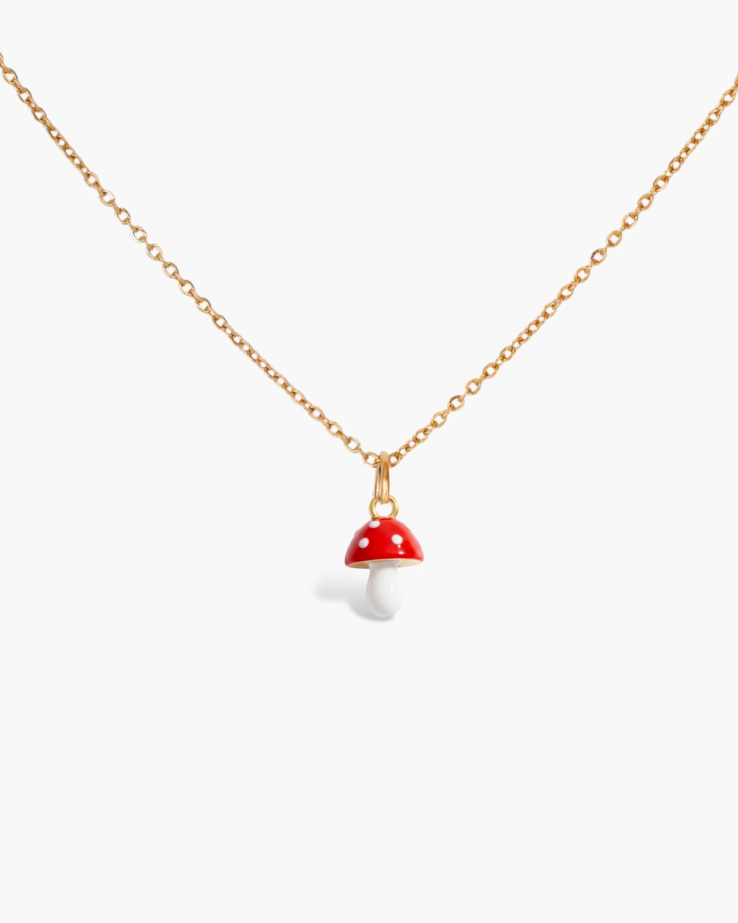 Gold chain necklace with a small red and white mushroom pendant on white background