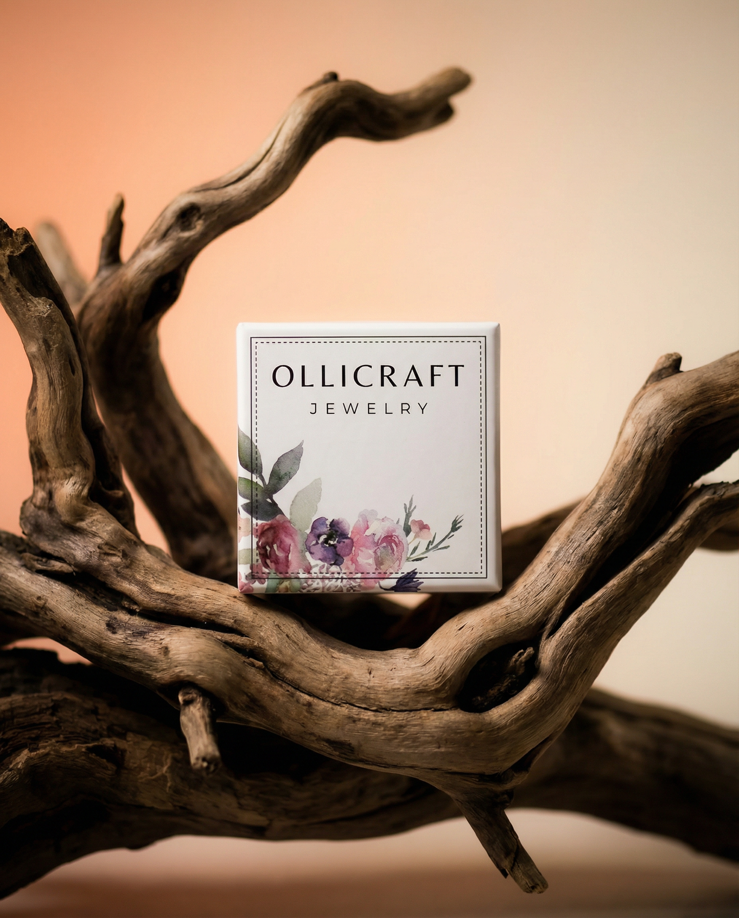 Elegant jewelry box with floral design displayed on natural driftwood, soft gradient background