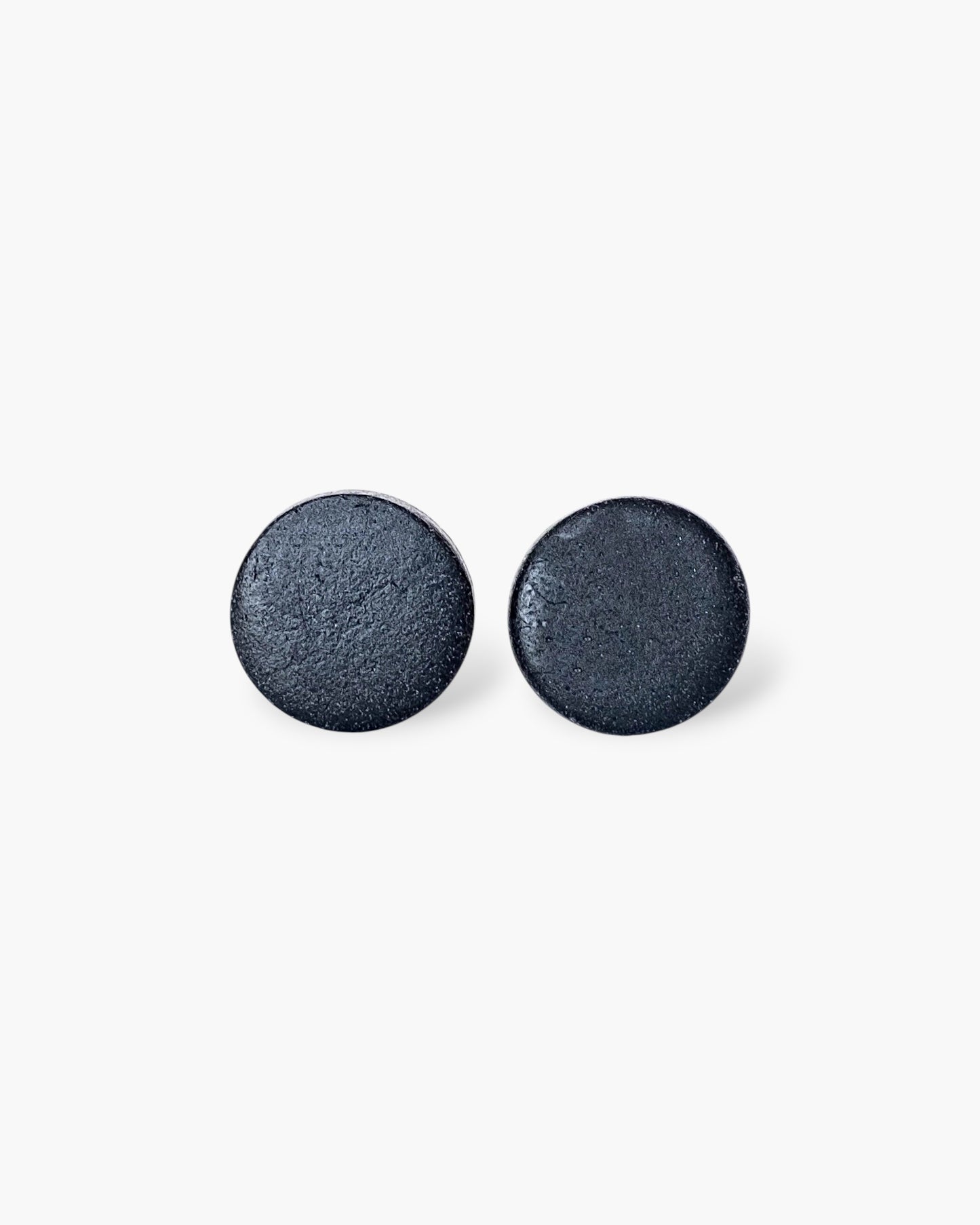 Minimalist black matte round stud earrings on white background