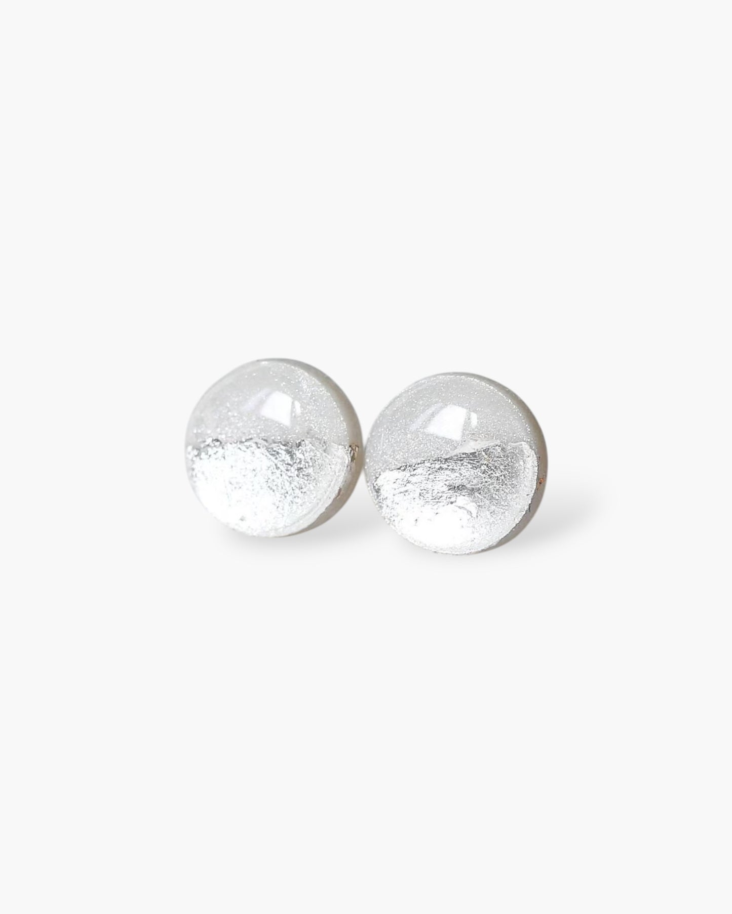 Pair of silver round earrings on a white background