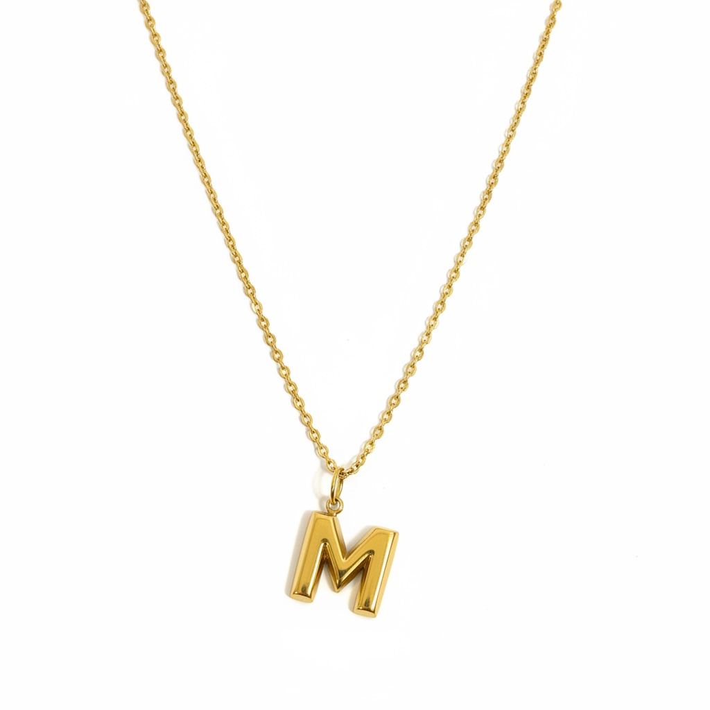 Gold chain necklace with a minimalist letter M pendant on white background