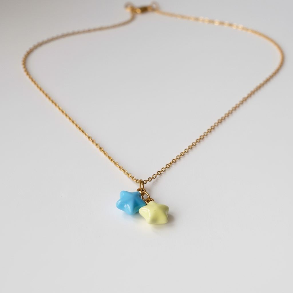 Gold chain necklace with blue and yellow star-shaped charms on white background
