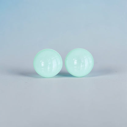 Minimalist mint green round stud earrings on a light background