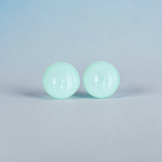 Minimalist mint green round stud earrings on a light background