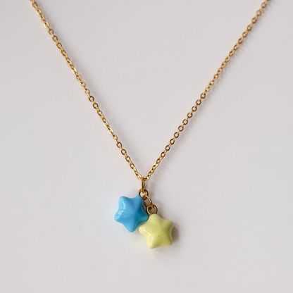 Gold chain necklace with blue and yellow star pendants on white background, handmade jewelry