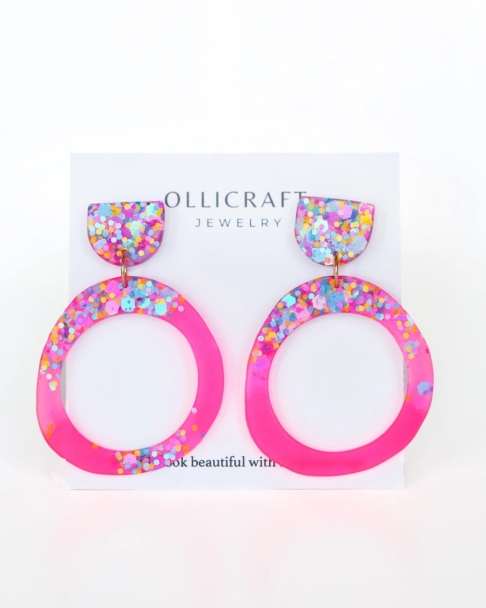 Colorful hoop earrings on a Ollicraft branded card with a white background