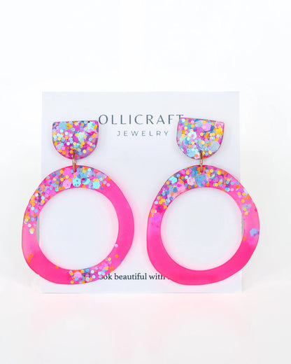 Colorful hoop earrings on a Ollicraft branded card with a white background