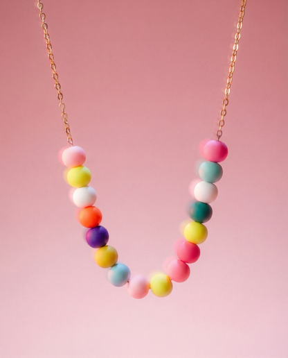 Necklace with colorful beads on a pink background