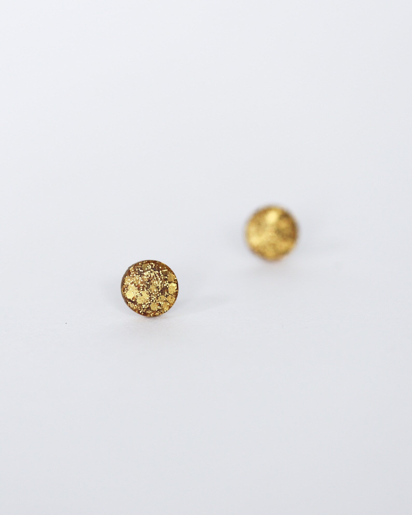 Two gold round beads on a white background