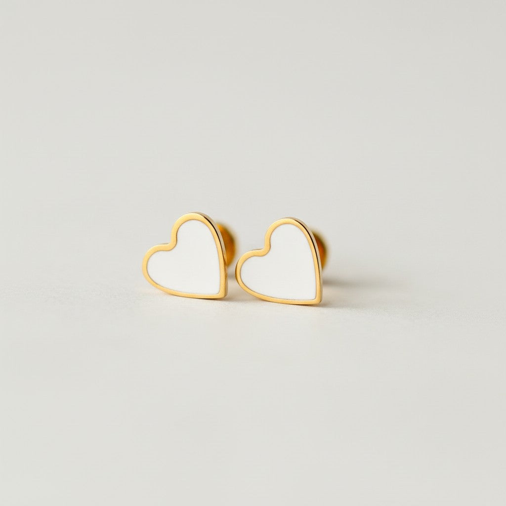 Minimalist gold heart stud earrings with white enamel, flat back, on neutral background