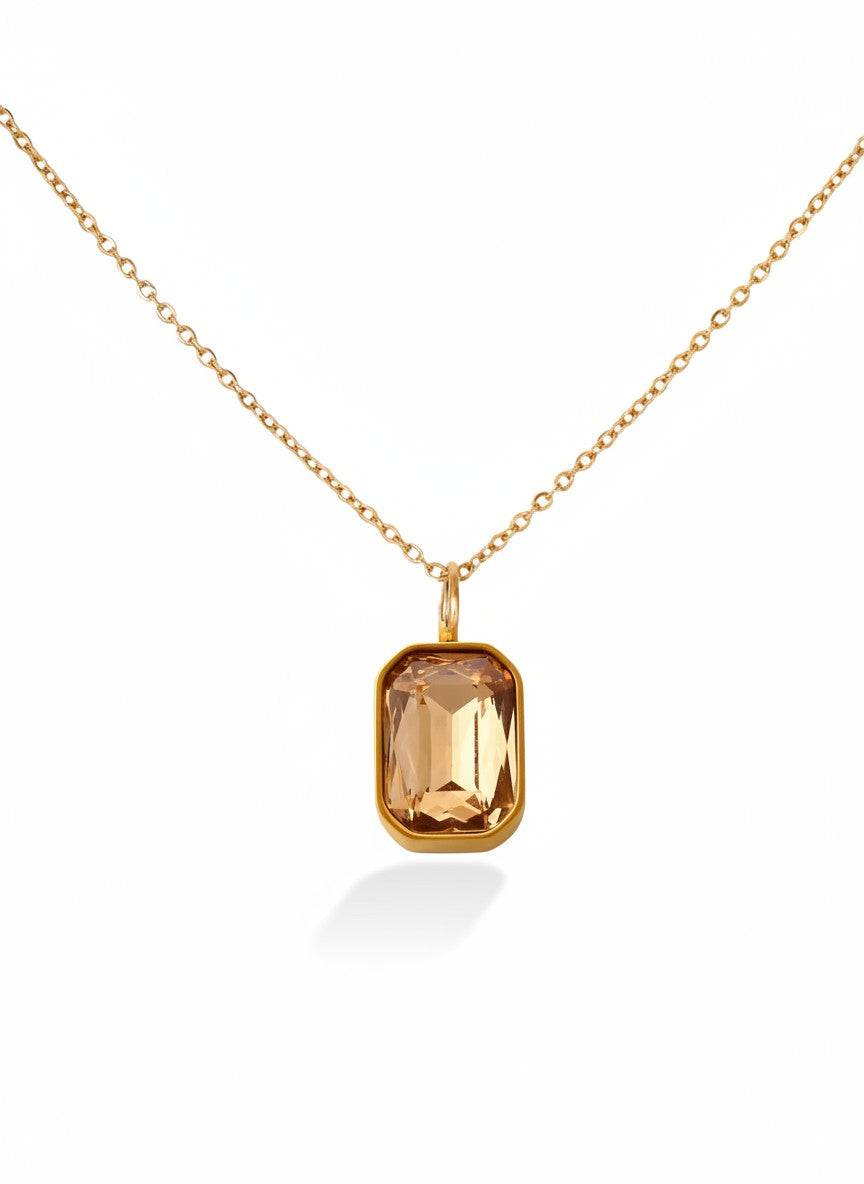 Minimalist gold chain necklace with rectangular gemstone pendant on white background