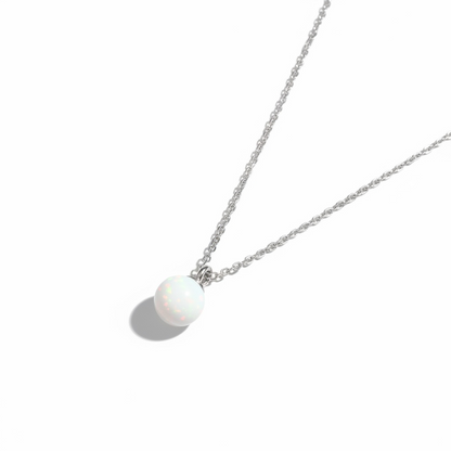 Minimalist silver chain necklace with a round opal gemstone pendant on white background