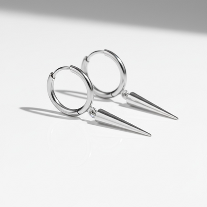 Minimalist silver hoop earrings with pointed spike dangles on a white background