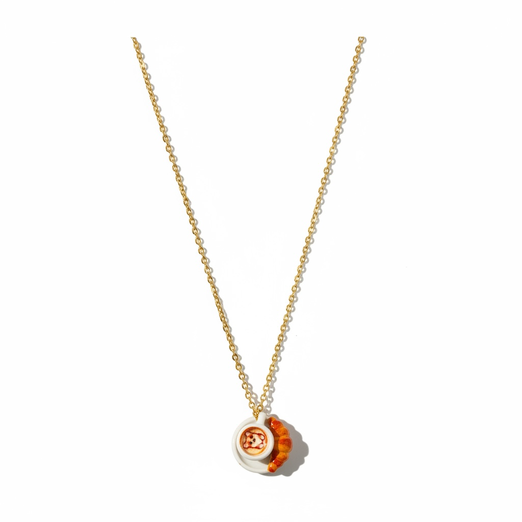 Gold chain necklace with miniature pizza and croissant pendants on white background