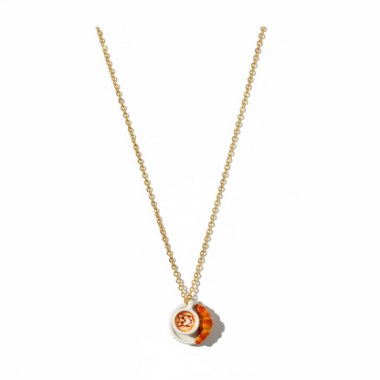 Gold chain necklace with miniature pizza and croissant pendants on white background