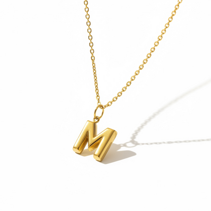 Gold letter M pendant necklace on a minimalist chain, handmade jewelry on white background