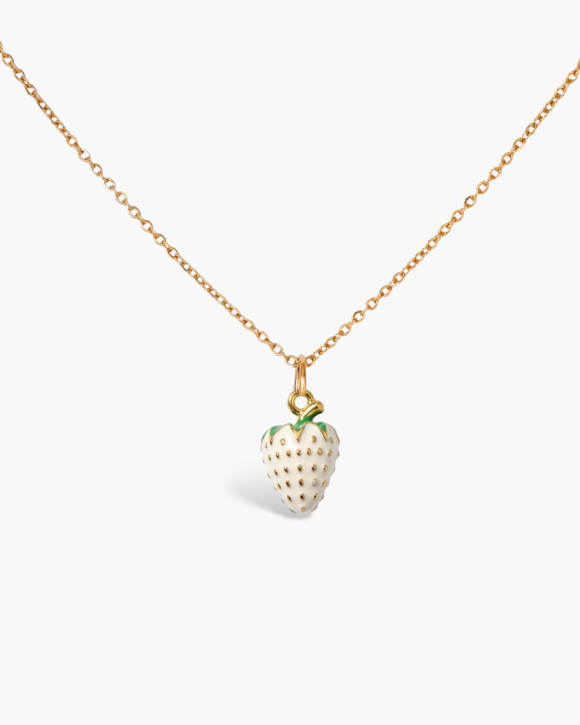 Gold chain necklace with a white strawberry charm pendant on a plain background