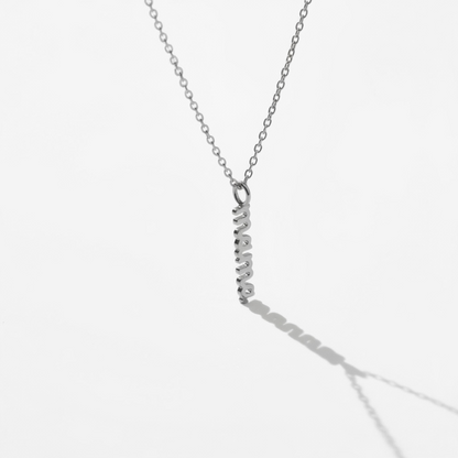 Minimalist silver necklace with vertical bar pendant on white background