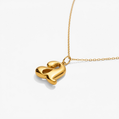 Gold initial pendant necklace with minimalist chain on white background