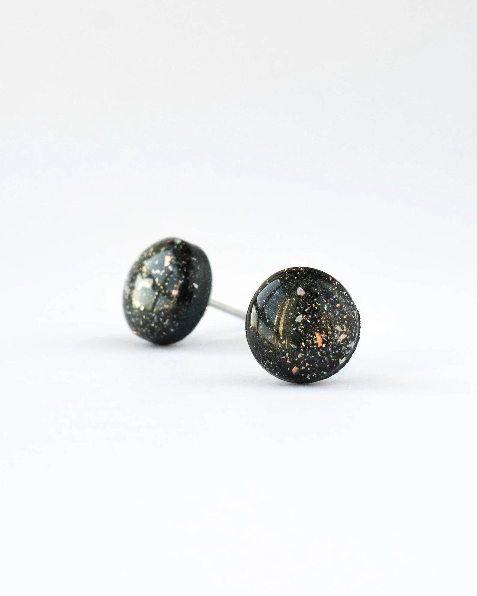 Pair of round stud earrings with a speckled design on a white background