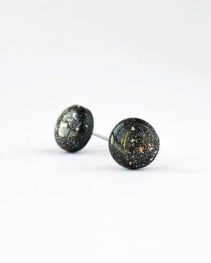 Pair of round stud earrings with a speckled design on a white background