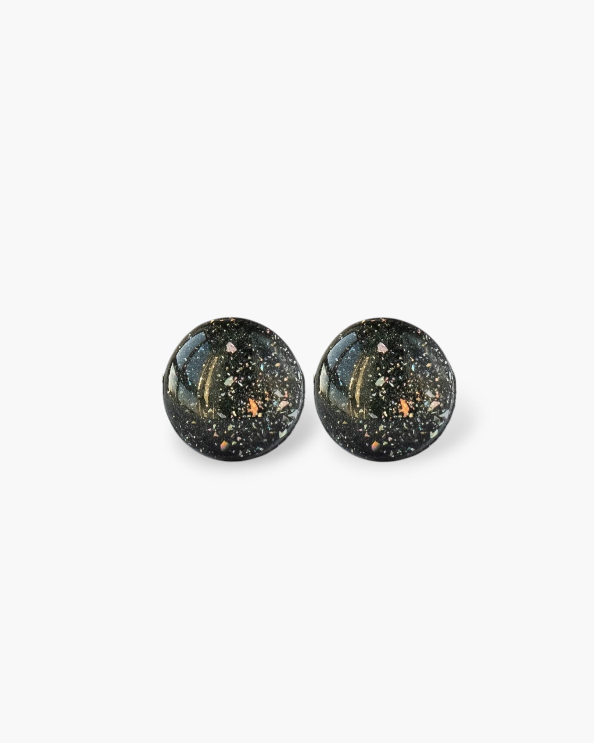 Pair of black round earrings with speckled design on a white background