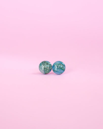 Pair of turquoise earrings on a pink background