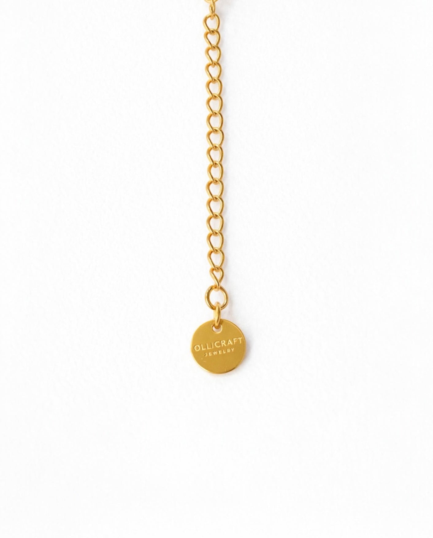 Gold chain necklace with a round pendant on a white background