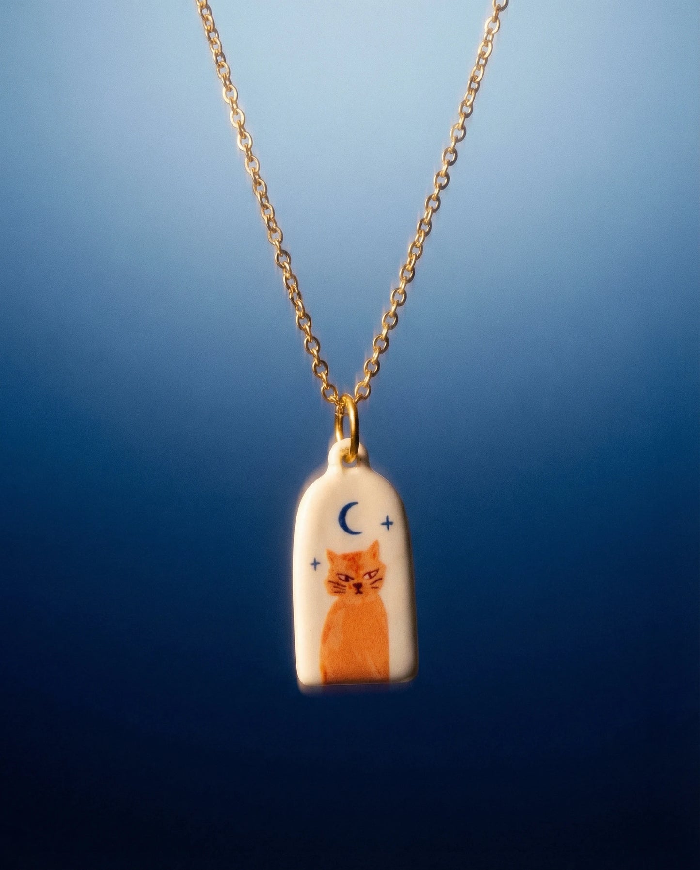 Necklace with a pendant featuring a cat design on a blue background