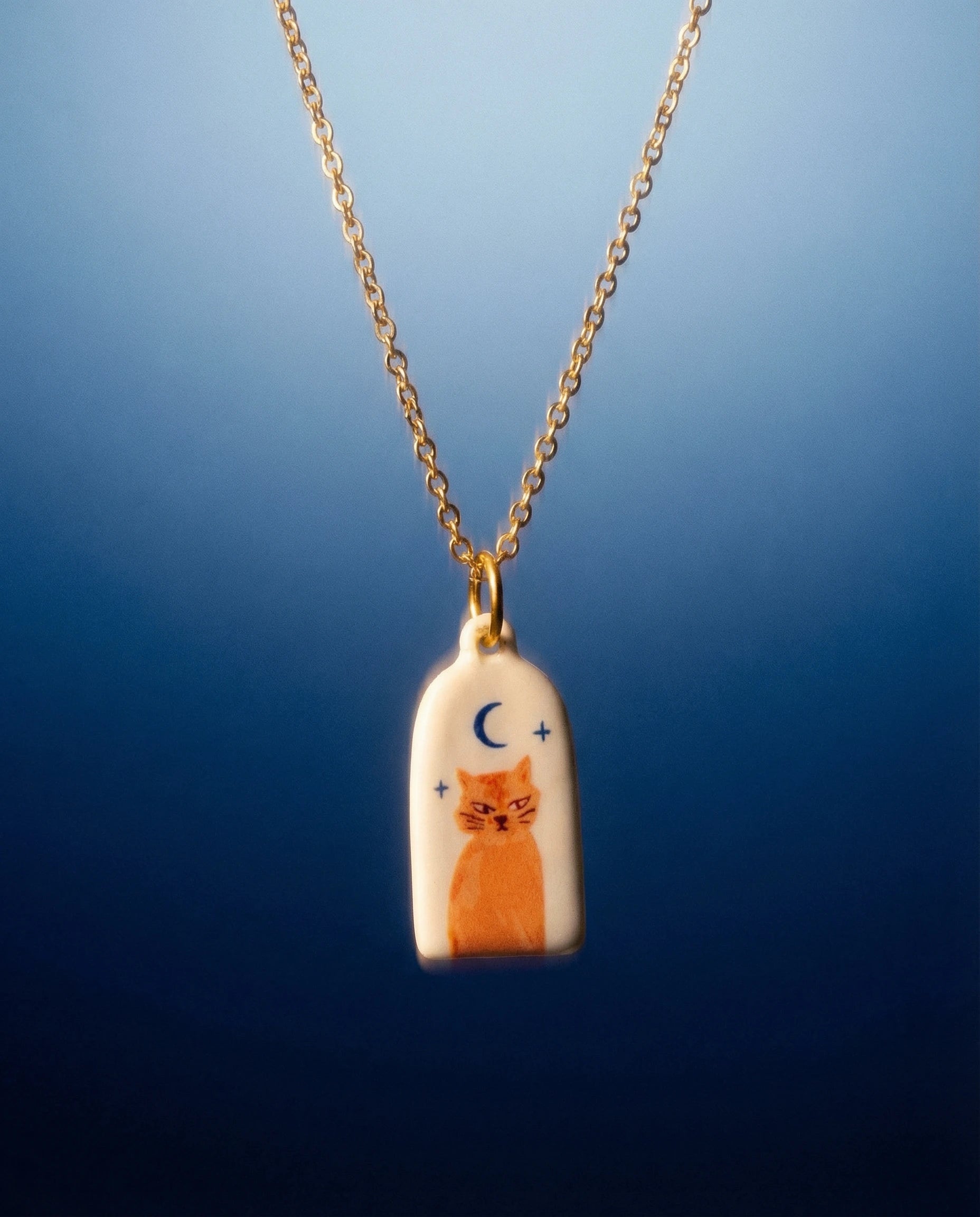 Necklace with a pendant featuring a cat design on a blue background
