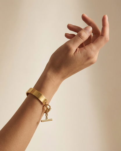 Gold stainless steel cuff bracelet with chain closure on wrist, minimalist jewelry