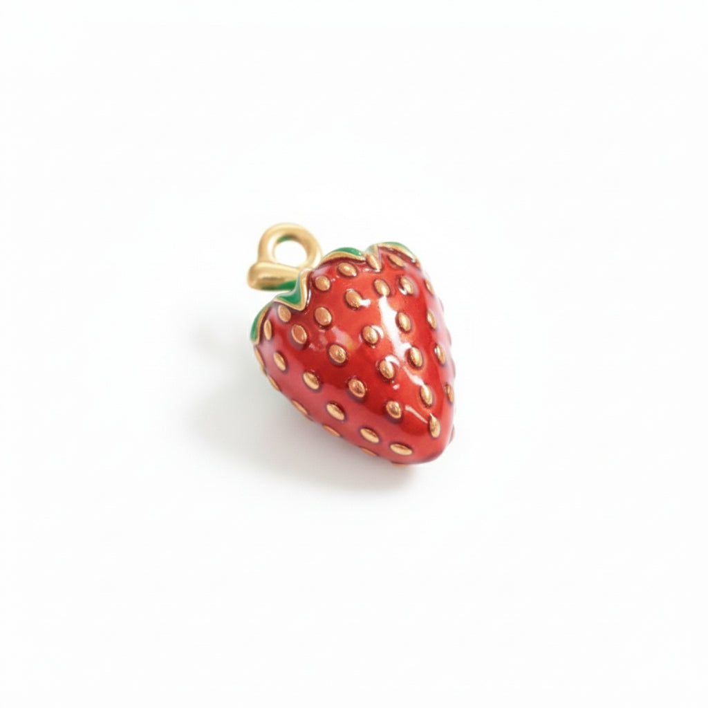gold and red strawberry charm pendant with green accents on white background