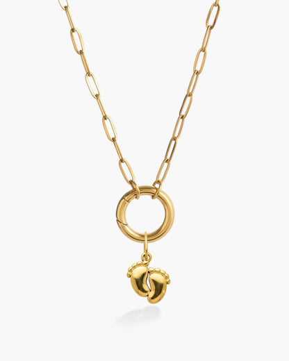 Gold chain necklace with baby feet pendant, minimalist handmade jewelry on white background