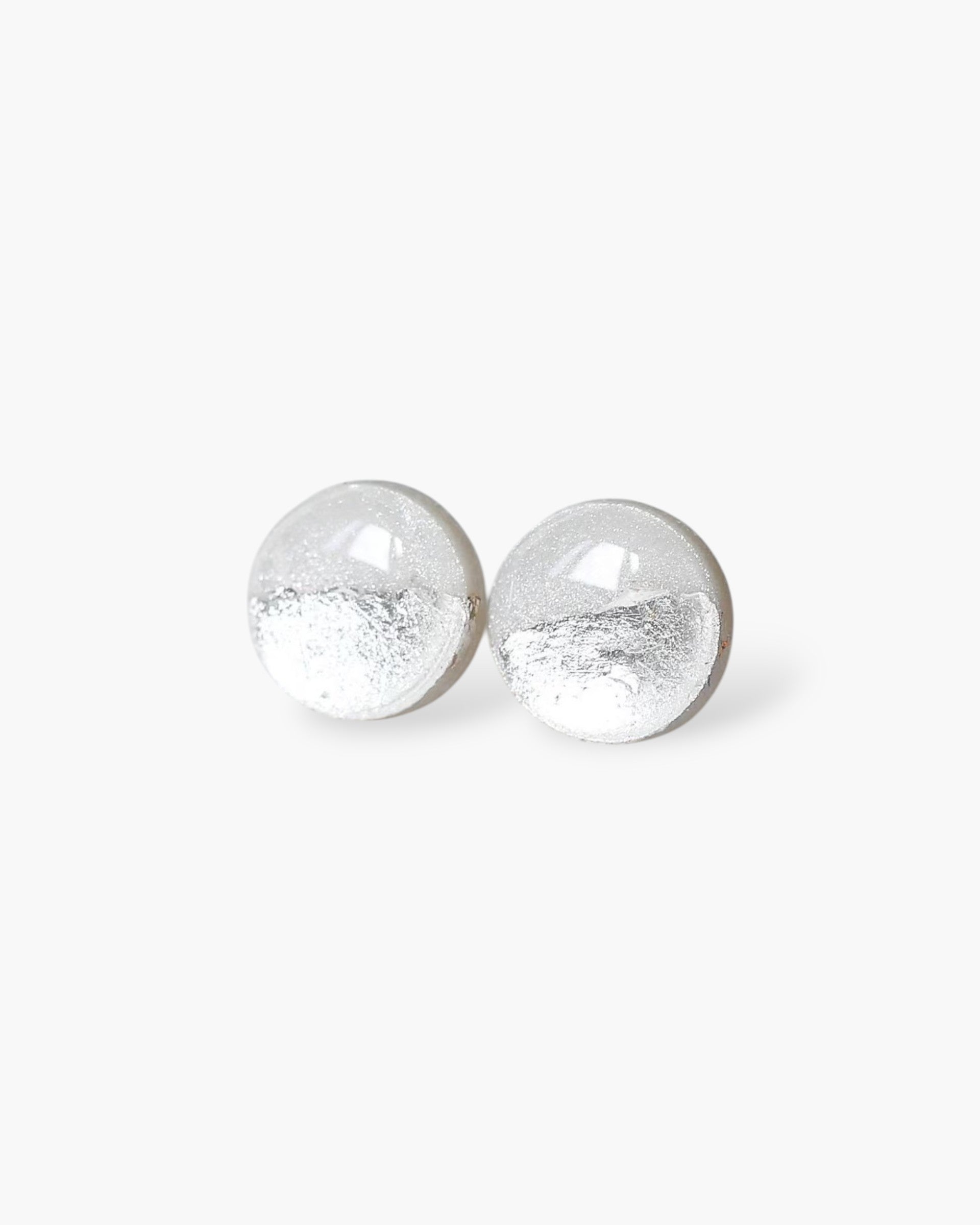 Pair of silver round earrings on a white background