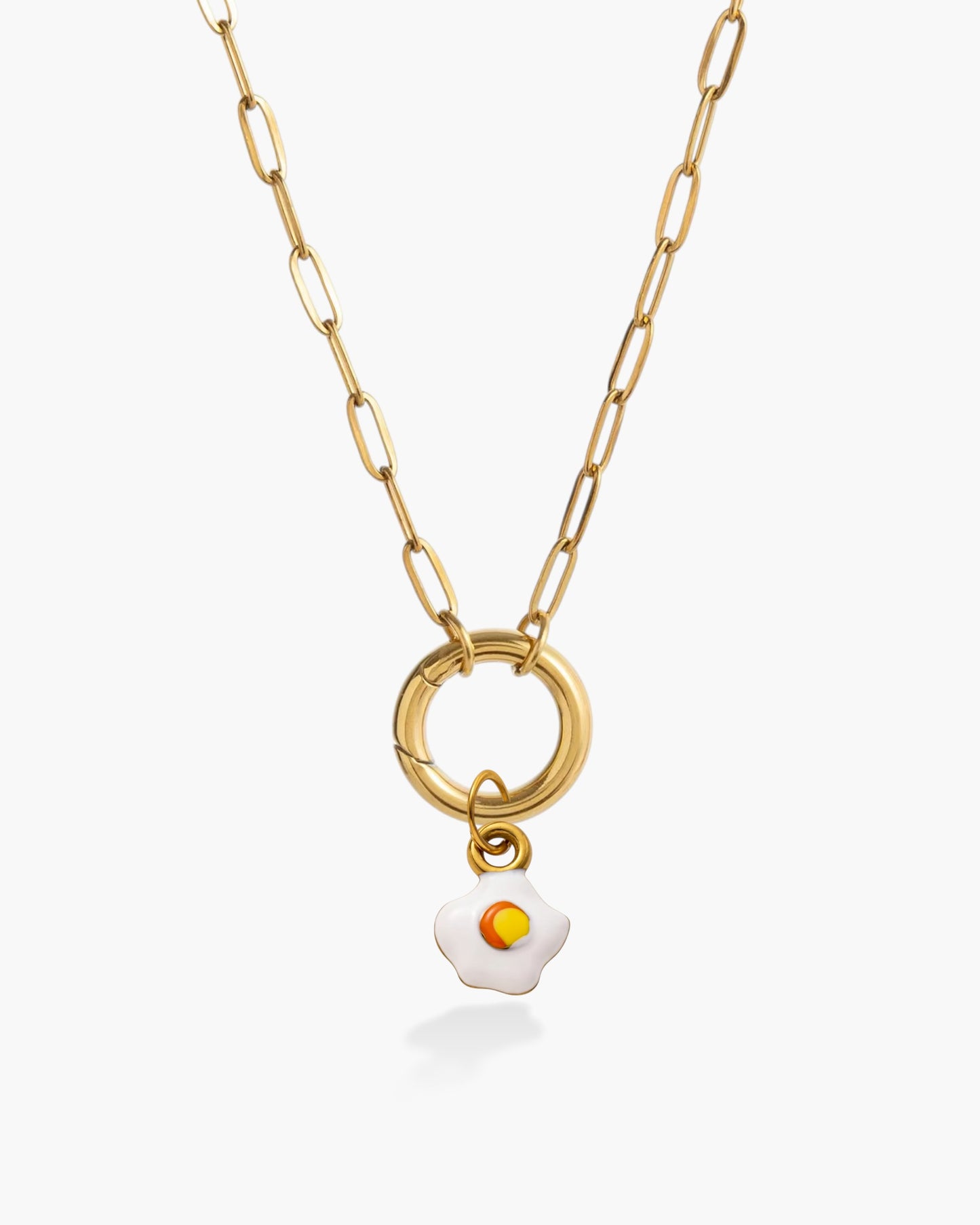 Gold chain necklace with a small fried egg charm pendant on a white background