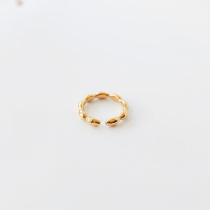 Ollijewelry minimalist gold ring with a polished beaded design and an open adjustable band on a white background.