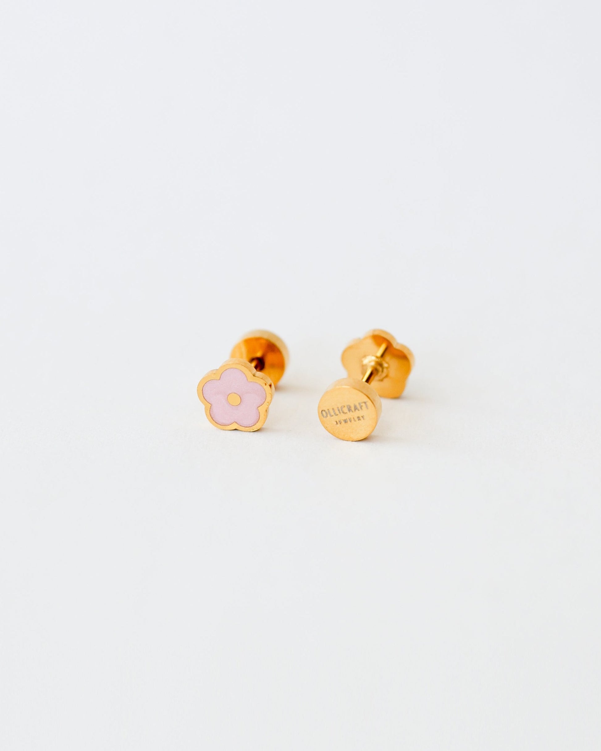 Ollijewelry gold-toned stainless steel flower stud earrings with pink enamel and comfortable flat back closure.