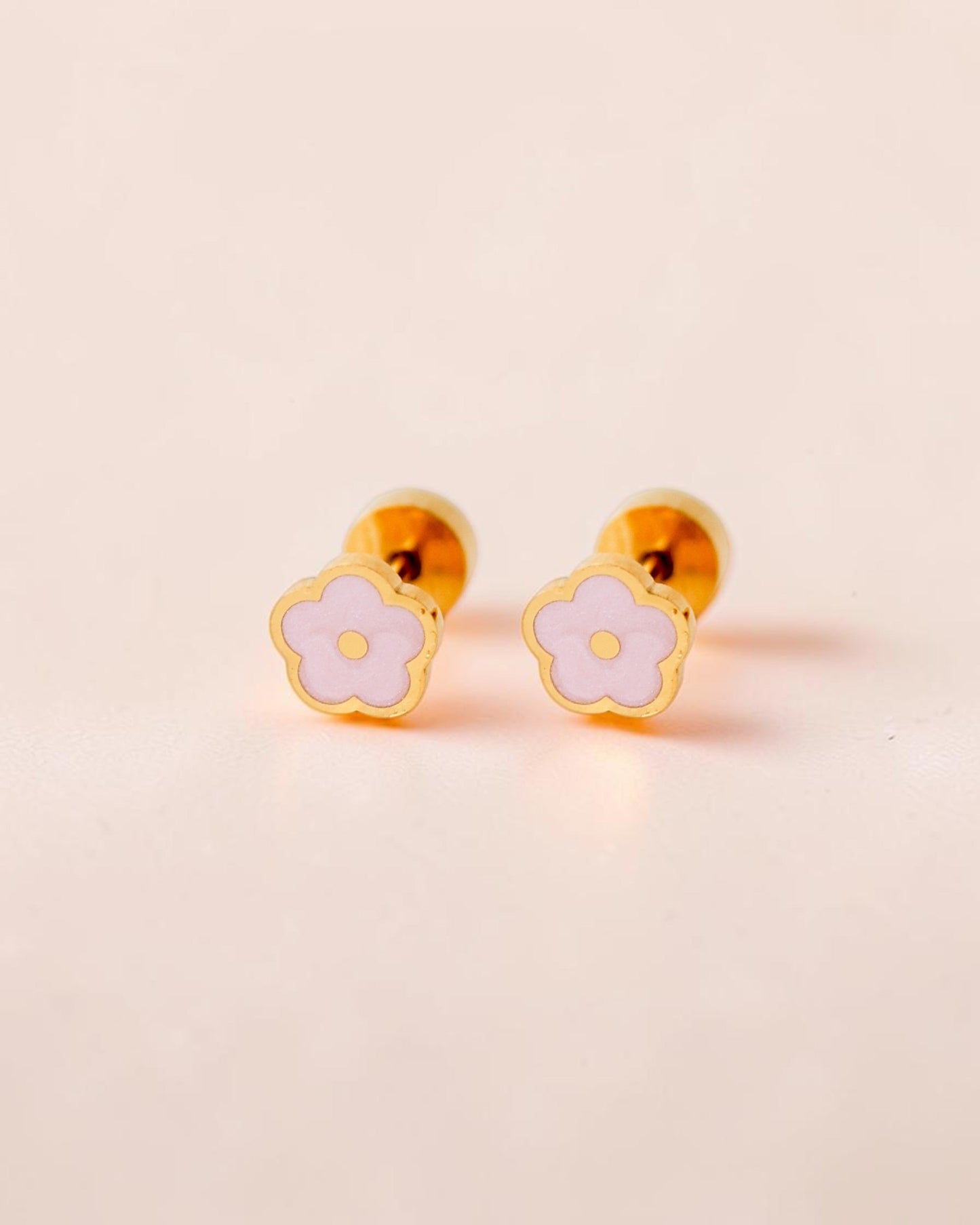 Ollijewelry pink flower flat back stud earrings in gold-toned surgical steel with enamel detailing on a soft background