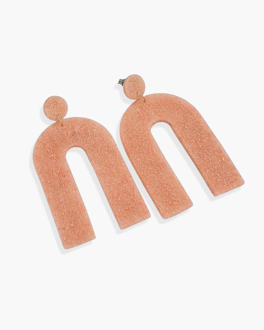 Pair of pink arch-shaped earrings on a white background