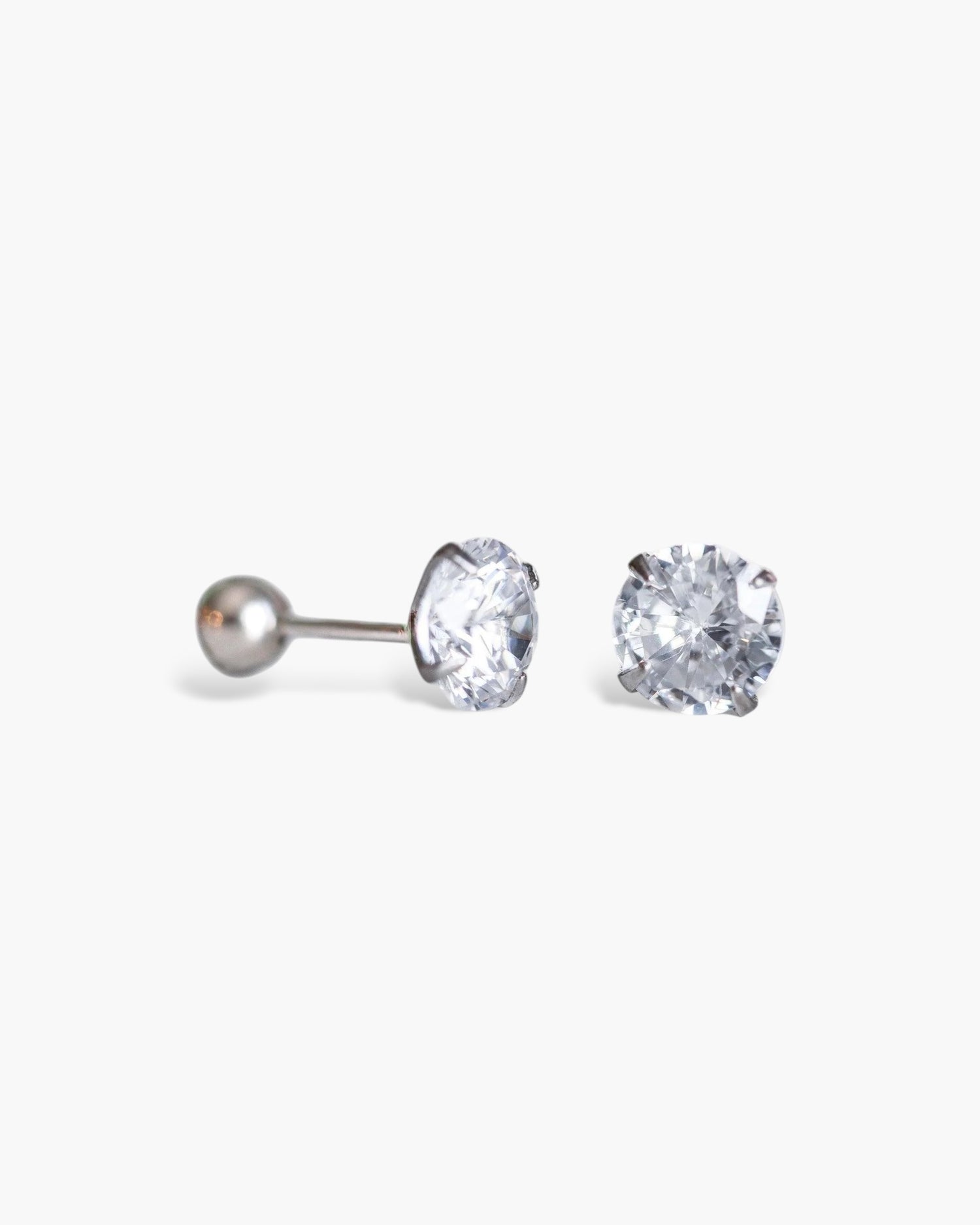 Pair of silver stud earrings with clear gemstones on a white background